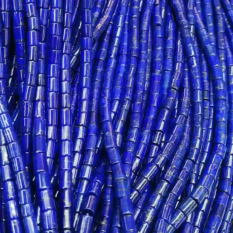 Premium commercial grade displaying what does lapis lazuli look like as long strands of intense blue tube crystal beads for wholesale buyers.