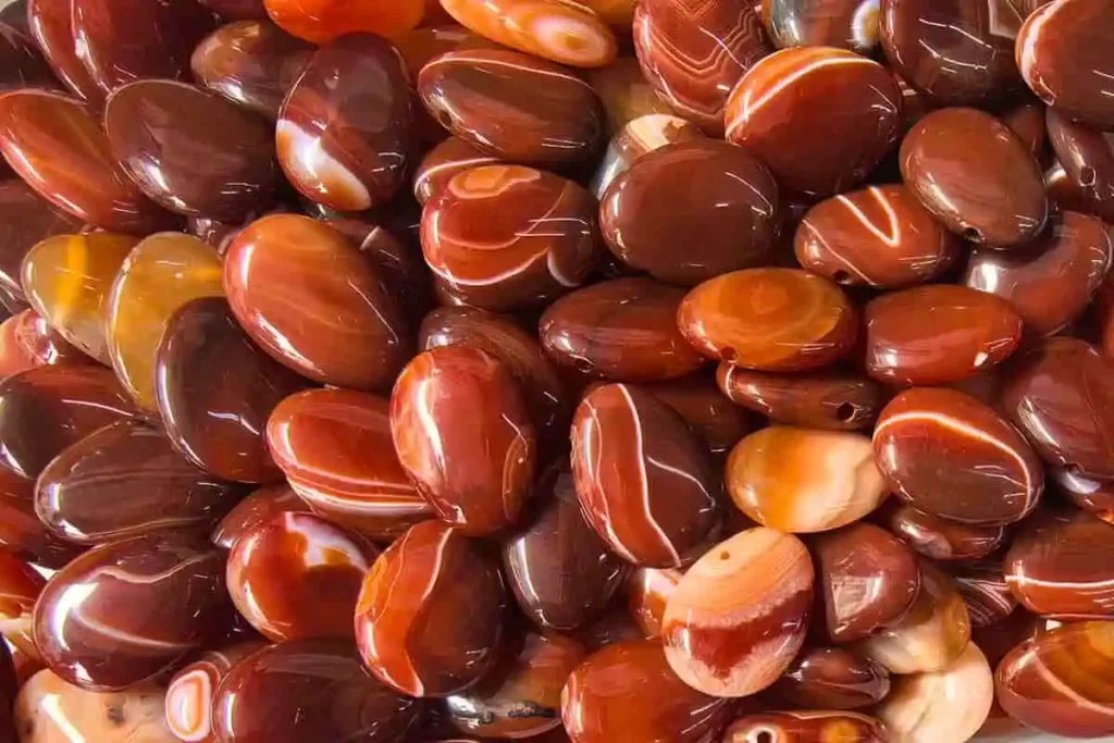 Bulk pierced Carnelian Agate beads showing natural orange and brown banding for jewelry making.