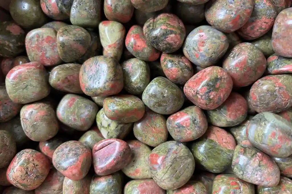 Smooth Unakite tumbled stone pieces for bulk sale, highlighting the natural beauty and traditional Unakite meaning.