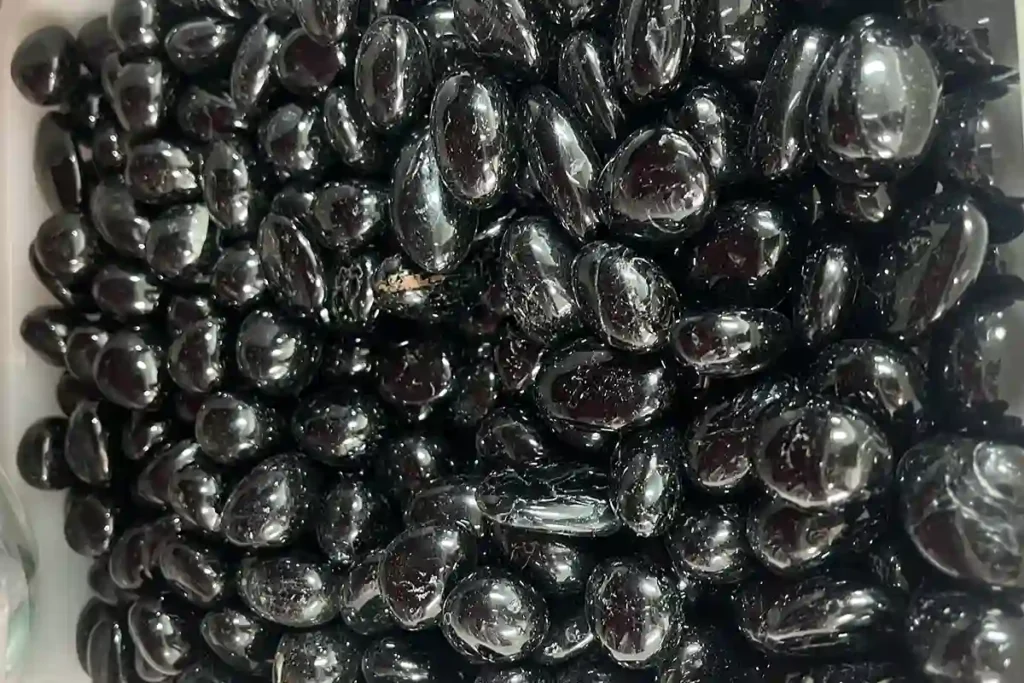 Black Tourmaline Meaning displayed with tumbled stones for protection, grounding, and crystal gift collections