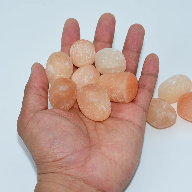 Peach Selenite Tumbled Wholesale stones displayed in a hand
