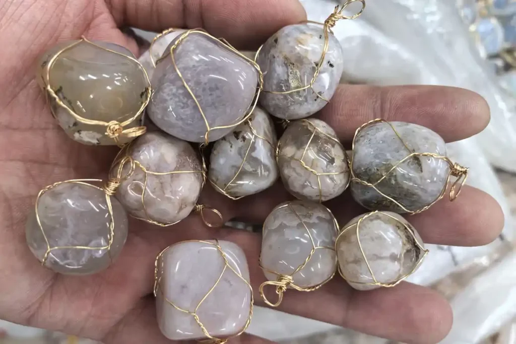 Flower Agate Meaning – polished Flower Agate tumbled stone with wire wrapping displayed by hand