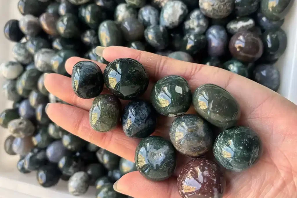 Moss Agate Meaning polished tumbled stones displayed in hand