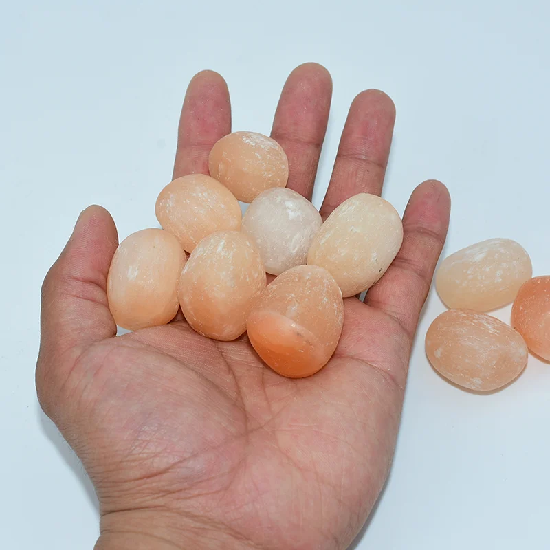 Peach Selenite Tumbled Wholesale pieces held in one hand