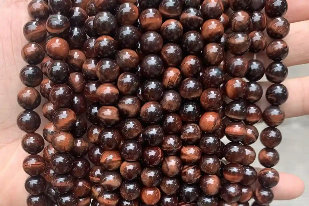 Polished 10mm gemstone beads illustrating Red Tigers Eye Meaning and natural bands