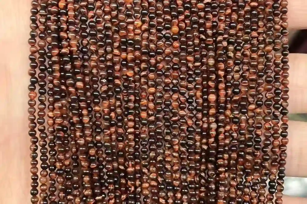 Red Tigers Eye Meaning shown with polished 4mm red tiger eye crystal beads