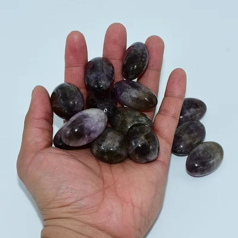 Ametrine Tumbled Stones Wholesale displayed in a hand for size reference