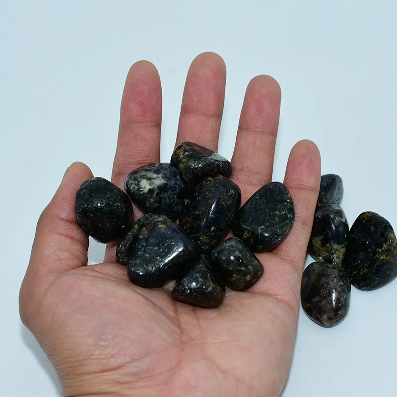 Iolite Tumbled Stones Wholesale held in hand to show the approximate size and angular shapes