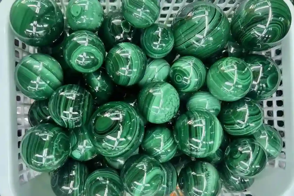 Polished malachite sphere with dark green banded patterns – Malachite Benefits