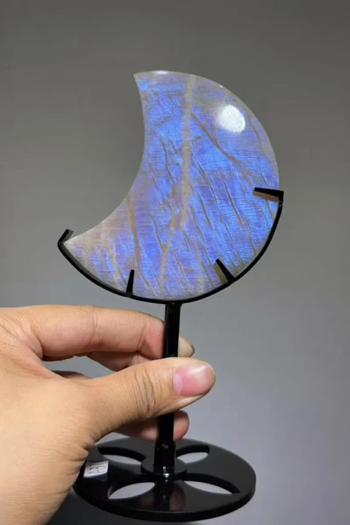 Rainbow Moonstone Benefits crescent moon stand with bright blue rainbow flash