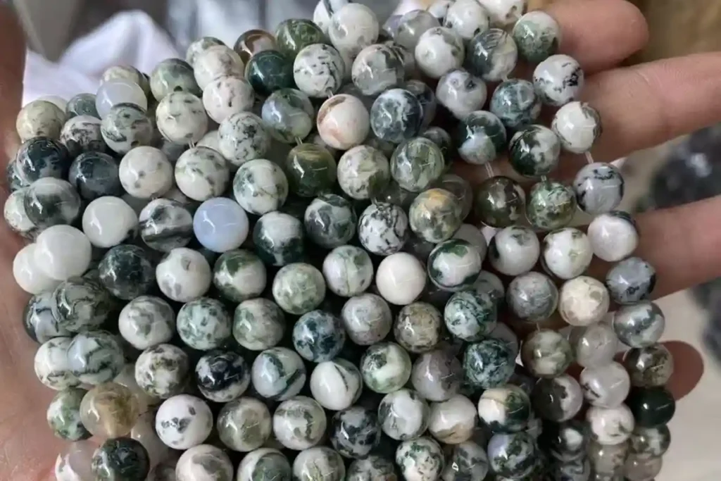 Tree Agate Meaning illustrated by 8 mm round beads with natural green markings on pale stone
