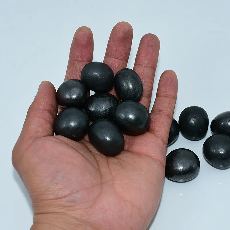 Shungite Tumbled Stones Wholesale displayed in hand