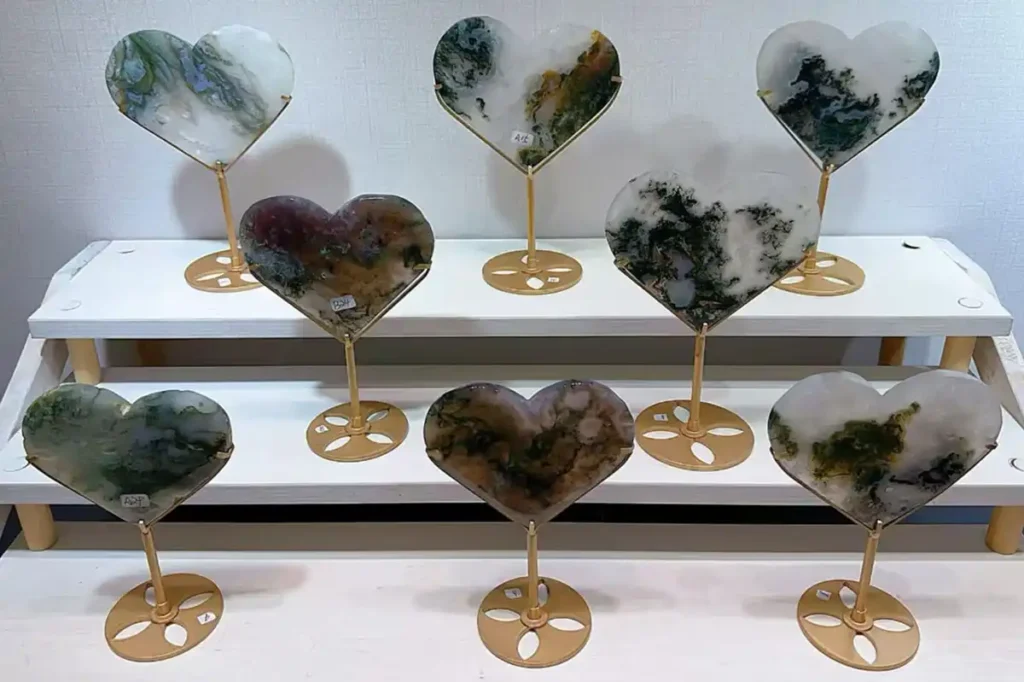 Tree Agate Meaning shown through heart-shaped crystal stands with green branch-like patterns`