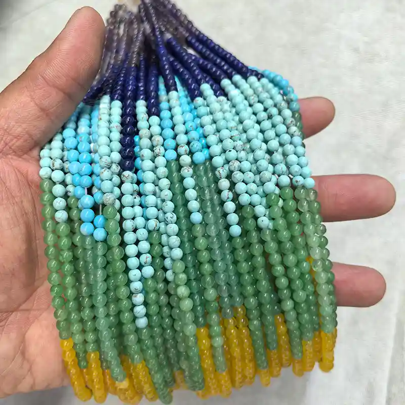 Chakra Beads Wholesale – 4 mm seven-color bead strands held in a hand