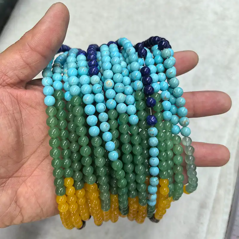Chakra Beads Wholesale – 6 mm multicolor bead strands displayed across a palm