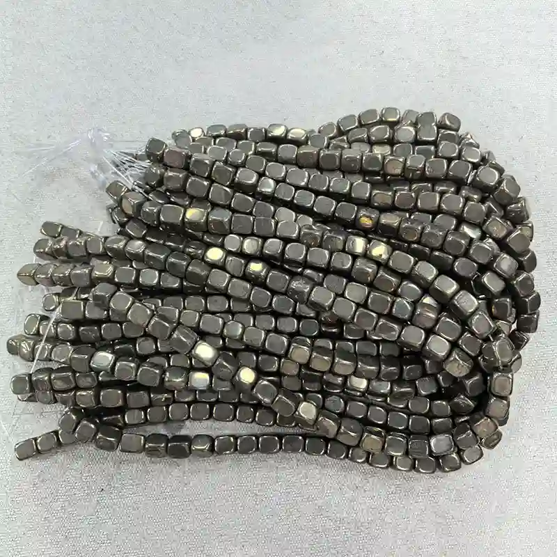 8x10mm Pyrite Beads Wholesale – top view of loosely coiled bead strands with metallic highlights