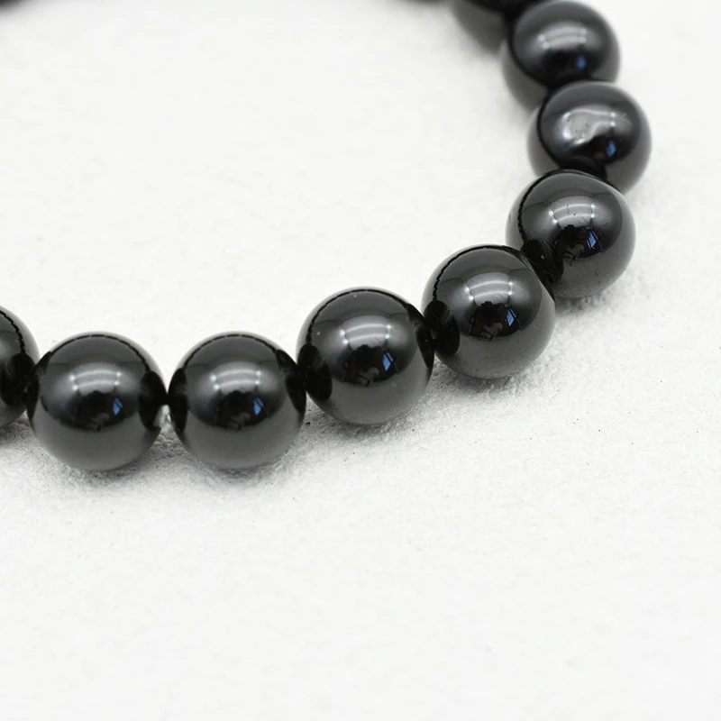 Black Spinel Bracelets Wholesale – close-up of glossy black round beads and bracelet stringing.