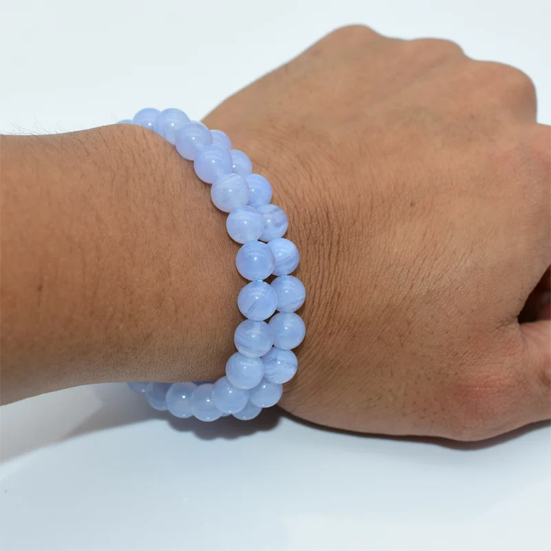 Blue Lace Agate Bracelet Wholesale shown on a wrist with polished pale blue round beads