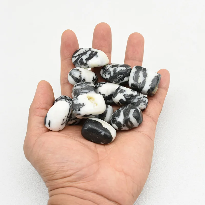 Zebra Jasper Tumbled Stone Wholesale – polished black and white stones held in an open palm