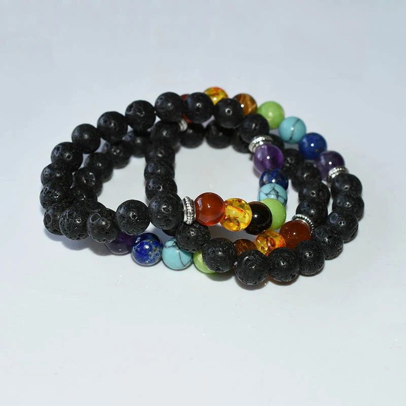 Chakra Bracelets Wholesale showing overlapping black lava bead bracelets with seven colored accents