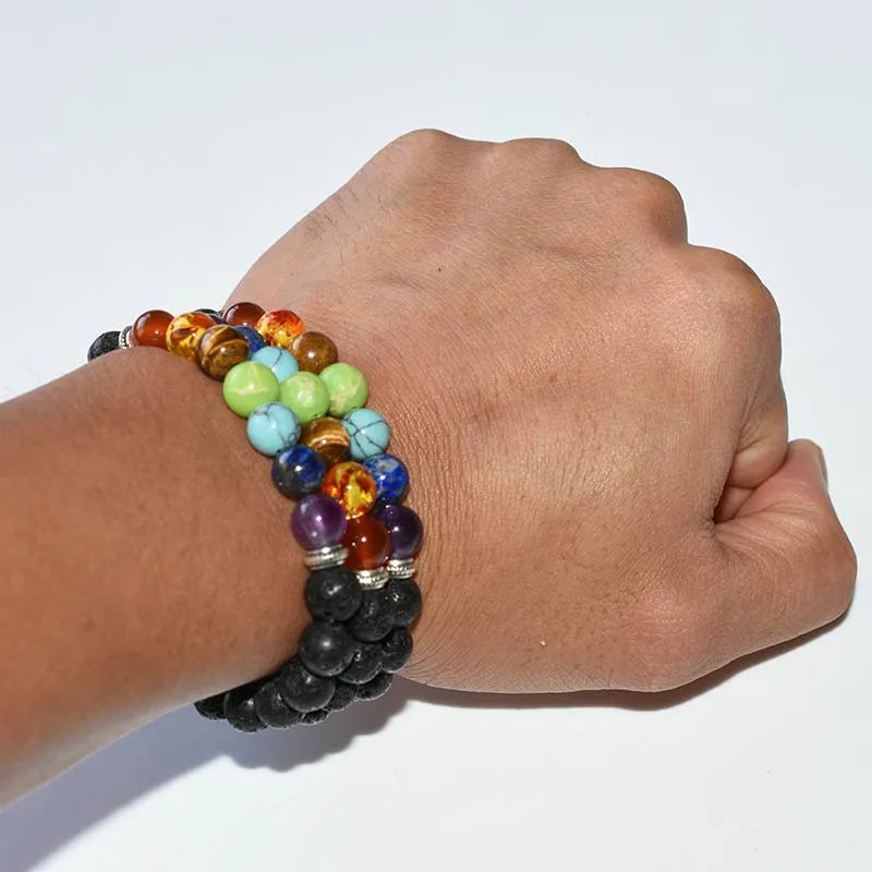 Chakra Bracelets Wholesale showing stacked black lava and multicolor bead bracelets worn on a wrist