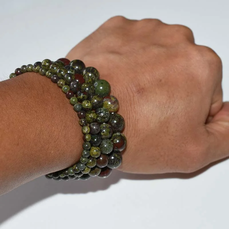 Dragon Blood Jasper Bracelet Wholesale showing multiple green and red bead bracelets worn on a wrist