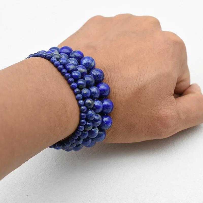 Lapis Lazuli Bracelet Wholesale showing several blue beaded bracelets stacked on a wrist