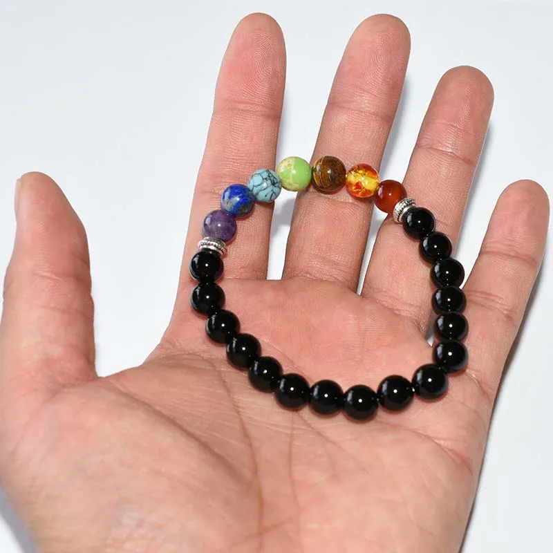 Mens Chakra Bracelet Wholesale displayed on an open palm with polished black and colorful round beads