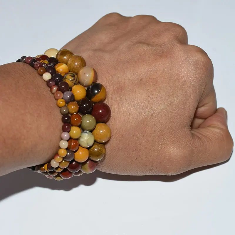 Mookaite Jasper Bracelet Wholesale showing mixed red and yellow bead bracelets stacked on a wrist