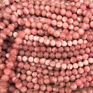 Rhodochrosite Beads Wholesale – close-up of pink gemstone bead strands with varied white patterns.