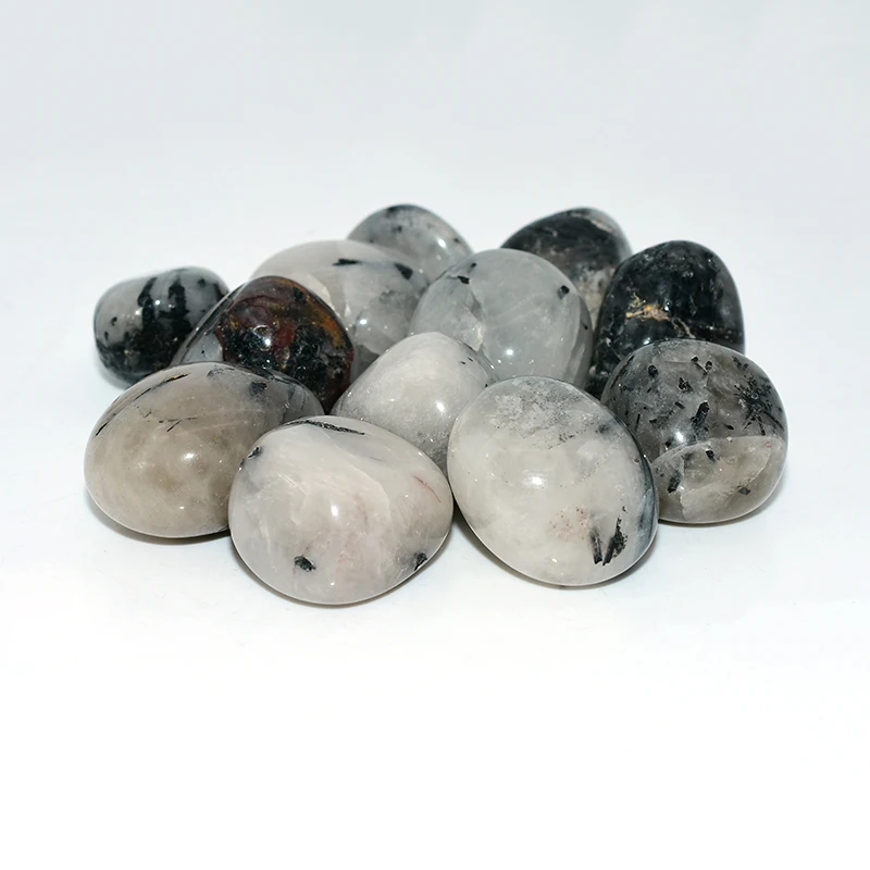 Tumbled Tourmalinated Quartz Wholesale – assorted white and translucent quartz stones on a white background